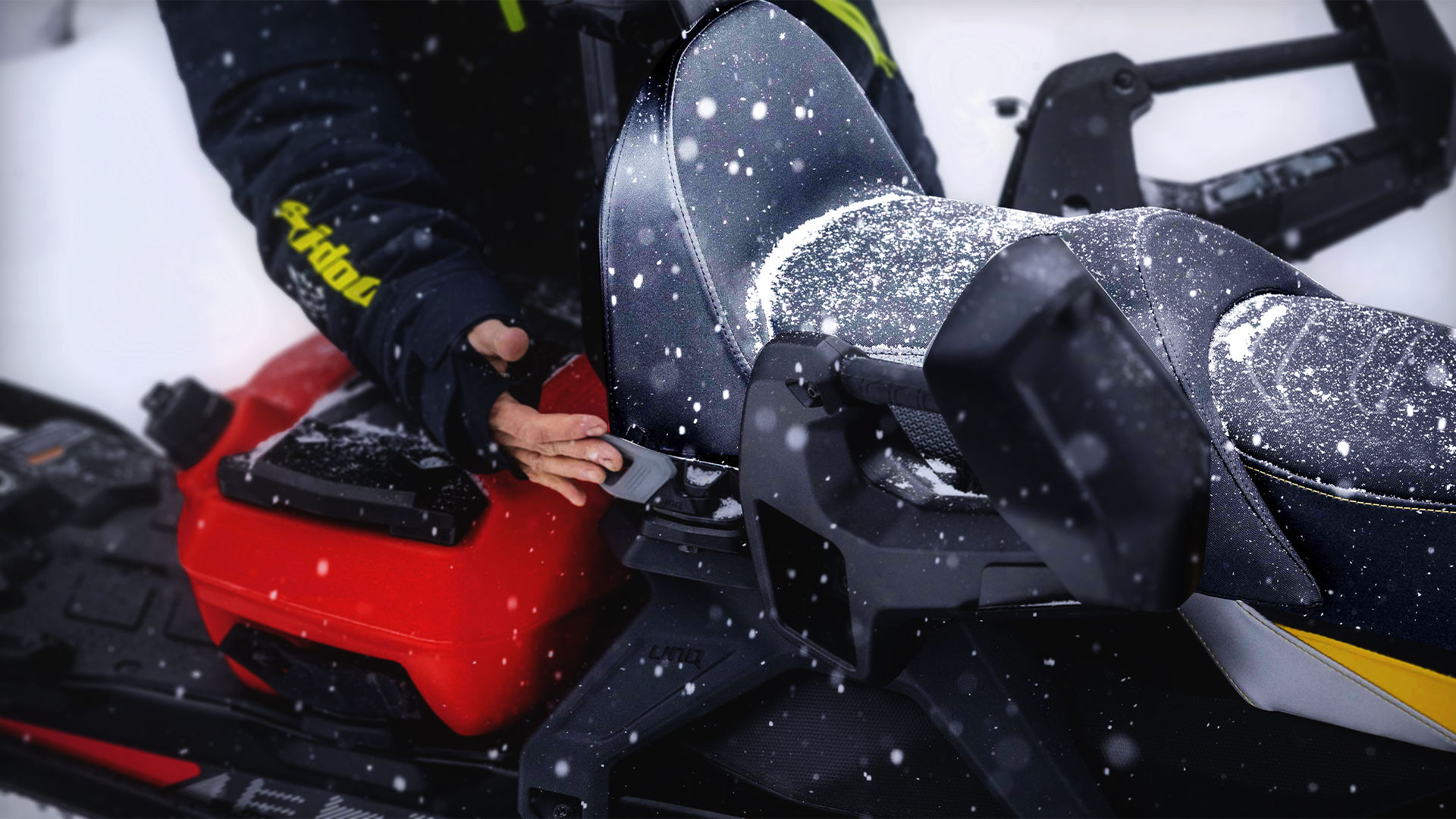 Women clipping a passenger seat on a Ski-Doo snowmobile