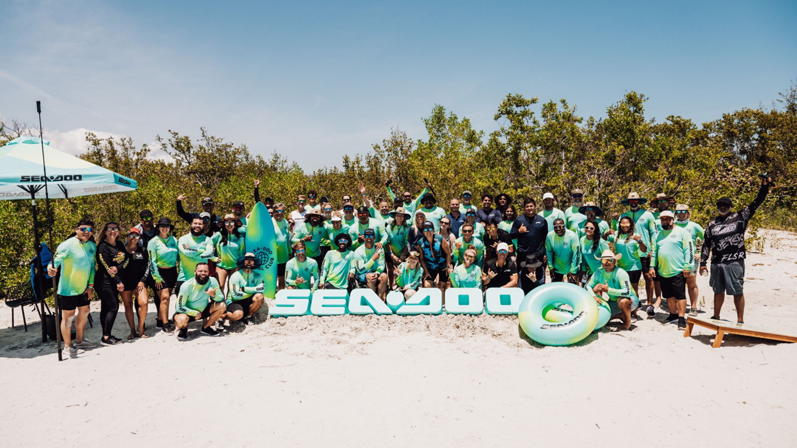 A large group at a Sea-Doo Social Club event on a beach