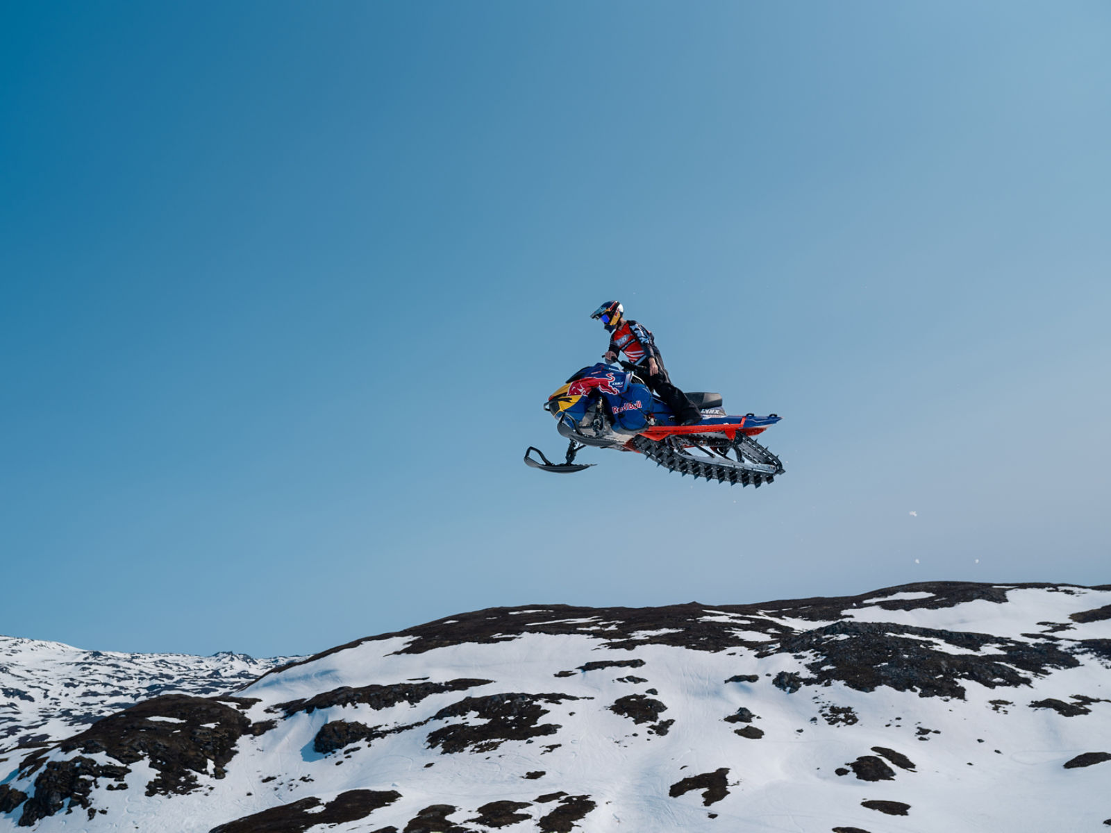 Lynx ambassador standing on his 2025 Lynx Shredder snowmobile.