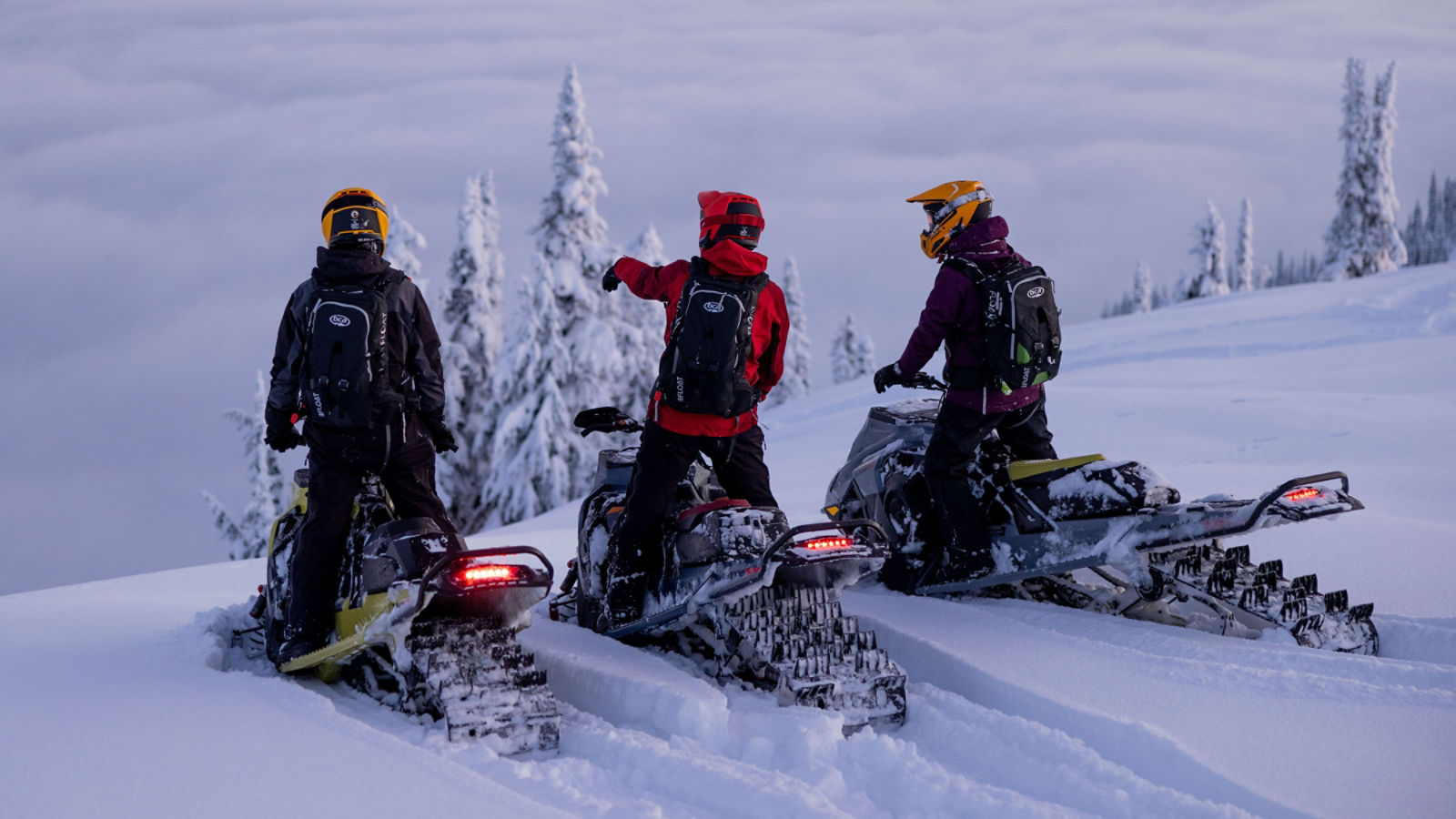 Three Lynx snowmobile riders at dawn