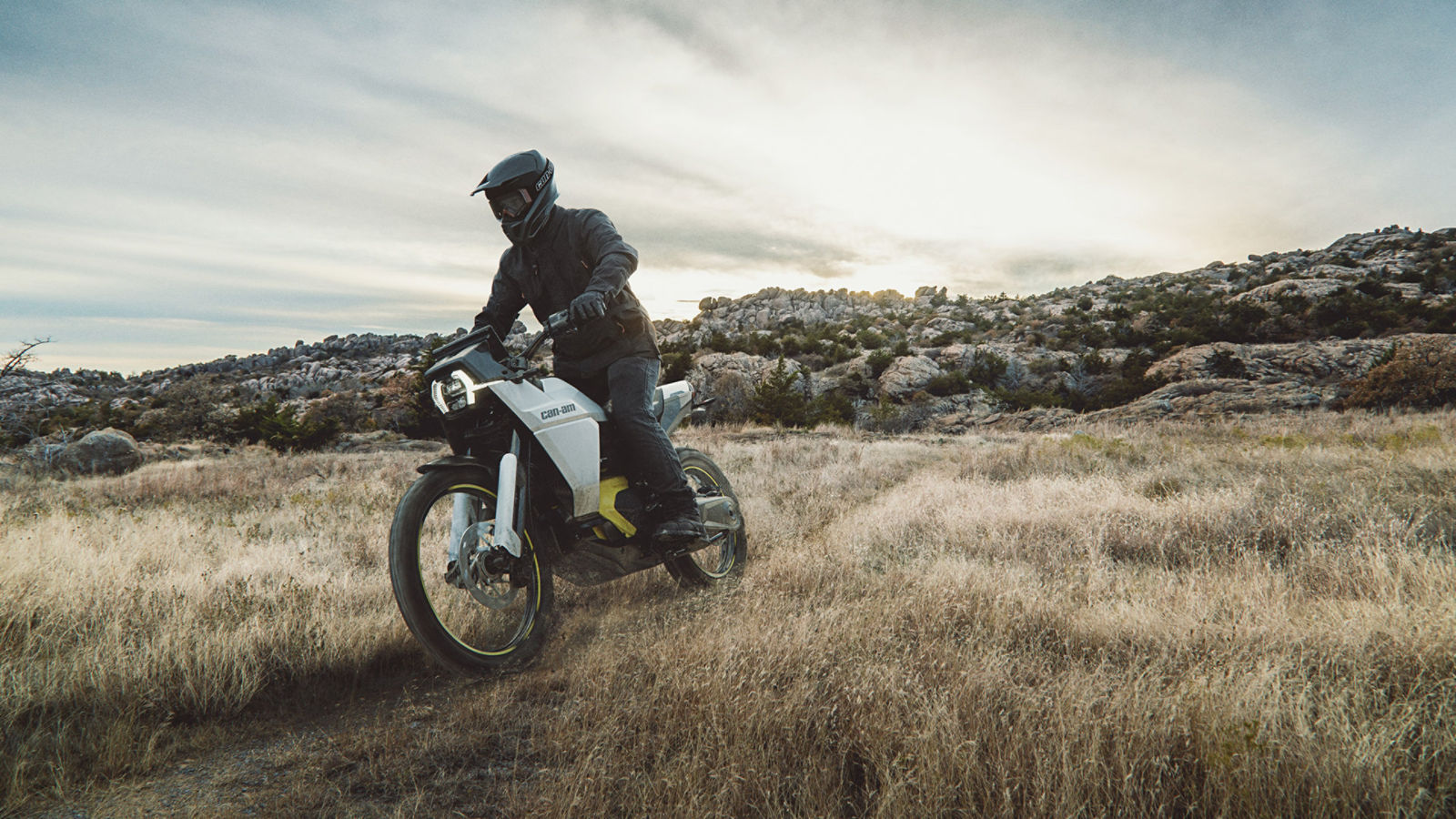 Un homme en randonnée sur une moto électrique Can-Am Origin dans un sentier