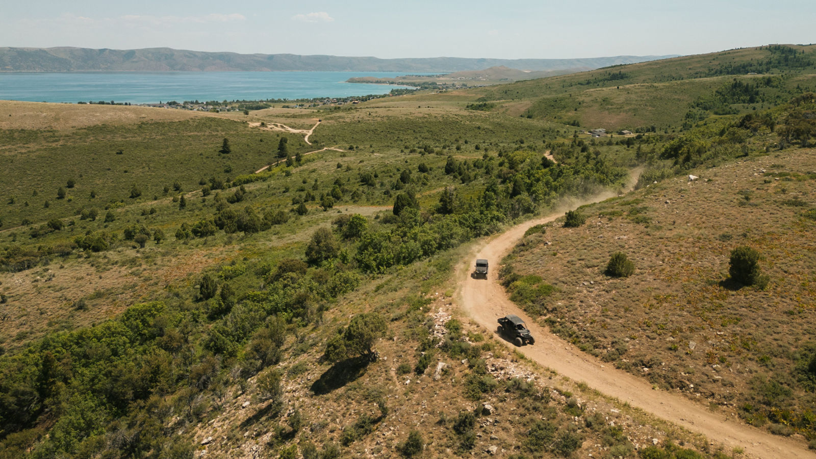 Deux véhicules côte-à-côte Can-Am sur un chemin de terre sur une colline