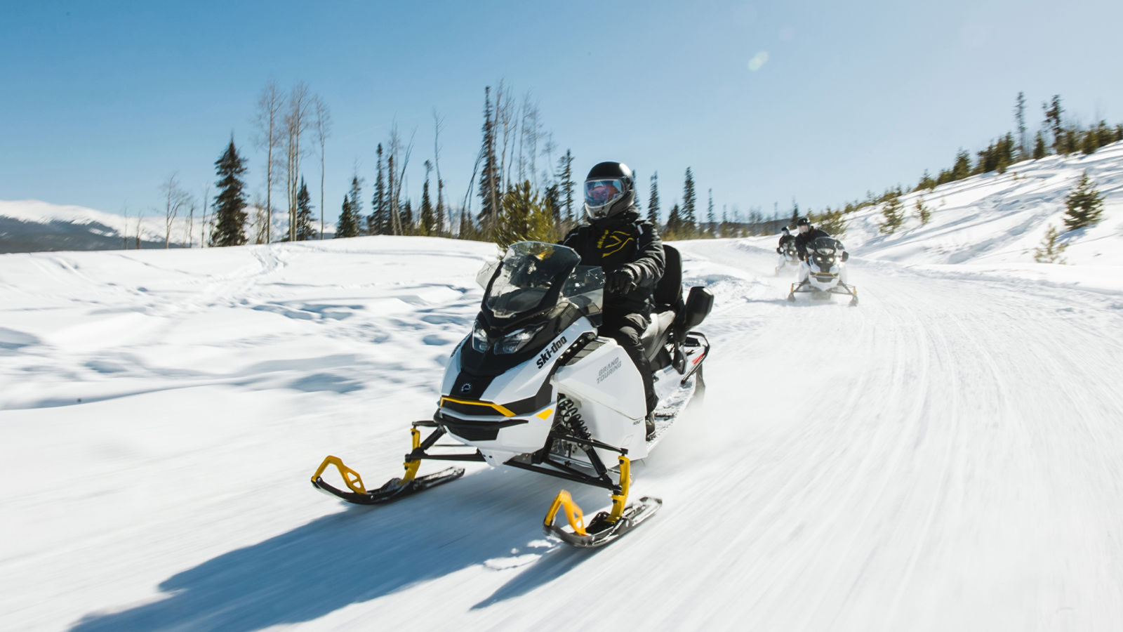 Deux motoneiges électriques Ski-Doo en randonnée sur un sentier enneigé