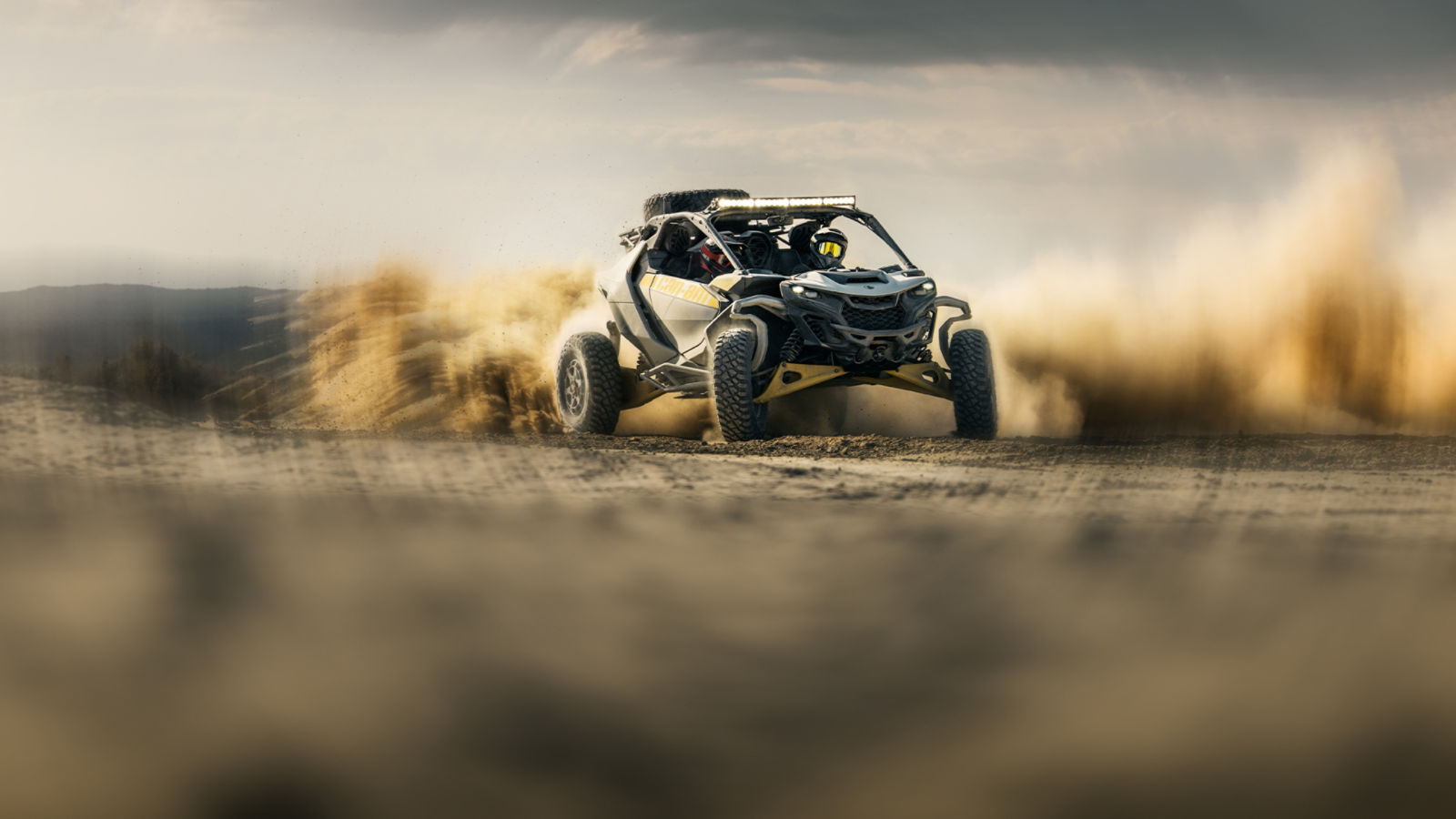 Hombre conduciendo un vehículo Can-Am Maverick R SxS por un sendero de tierra