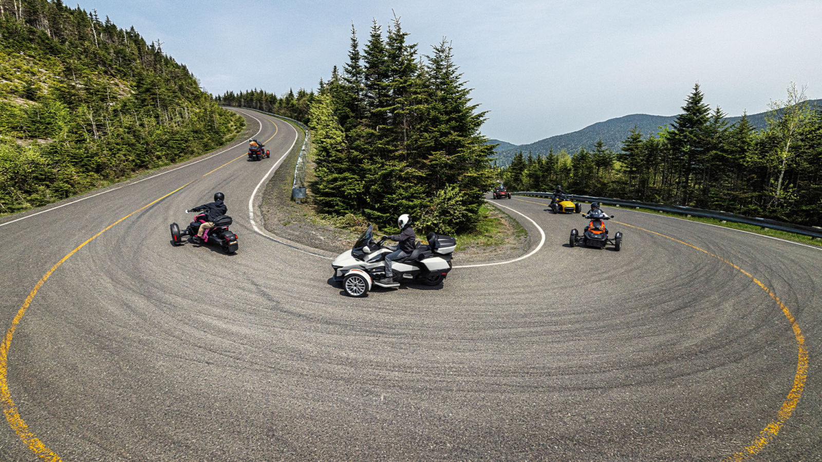 Group of Can-Am 3-wheel motorcycles riding up a hill