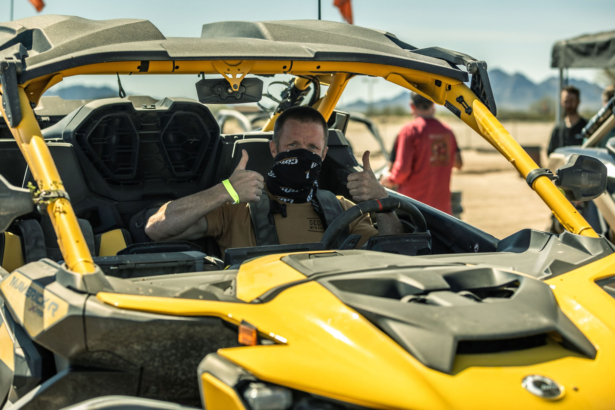 A rider giving thumbs up on his Can-Am Maverick R Side-by-Side vehicle