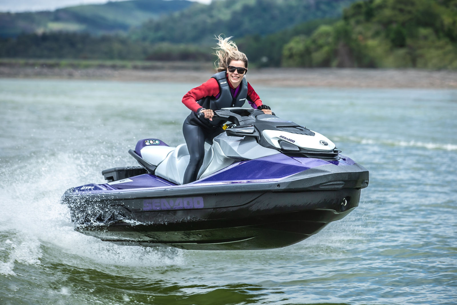 Mulher a bordo de um Sea-Doo em movimento, sorrindo para foto
