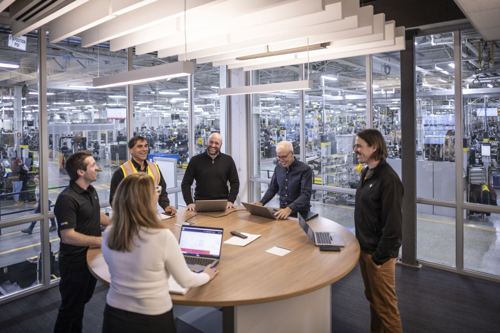Empleados alrededor de una mesa durante una reunión en unas instalaciones.