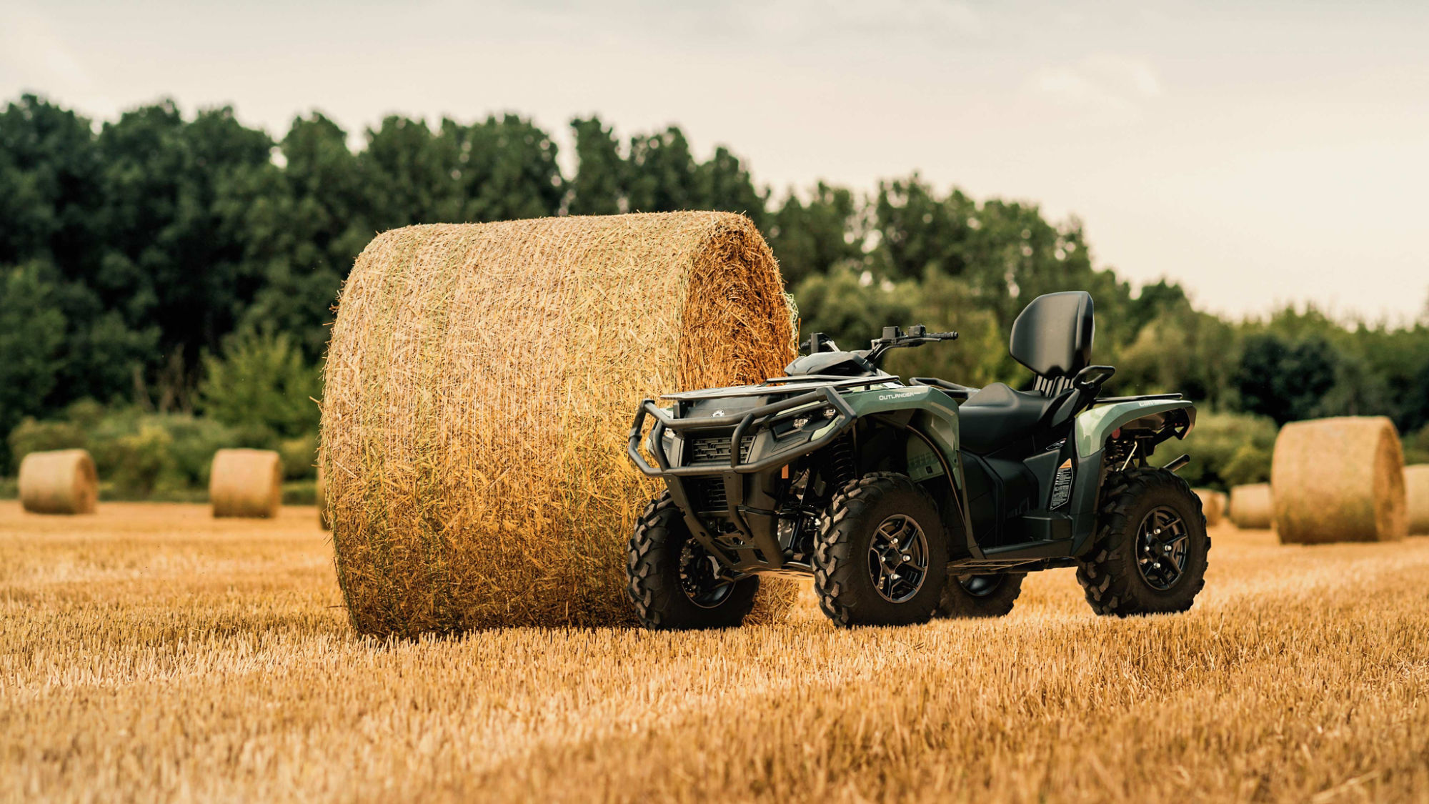 A Can-Am ATV designed for the farm, sitting next to a bale of hay