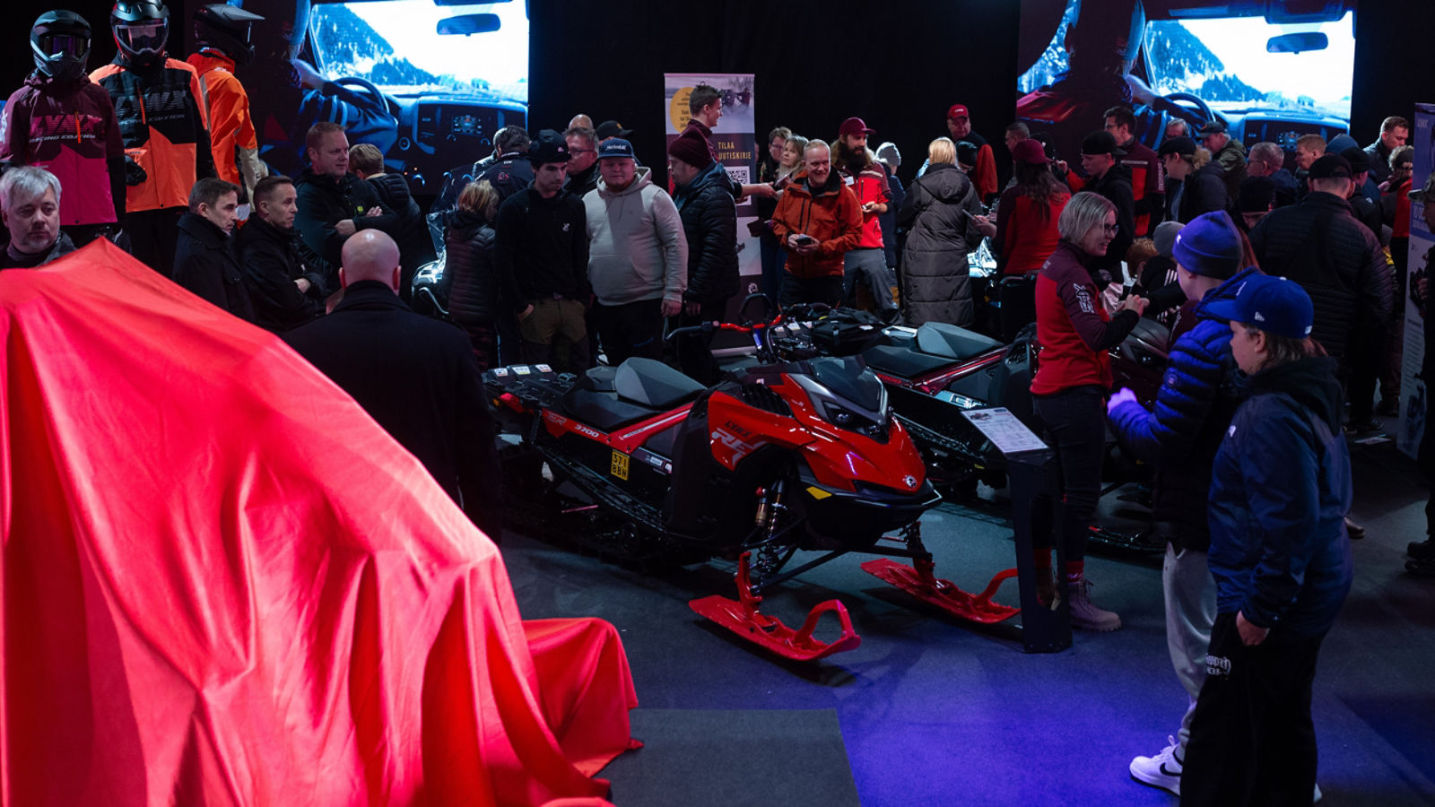 Människor samlade runt Lynx-snöskotrar i en mässhall