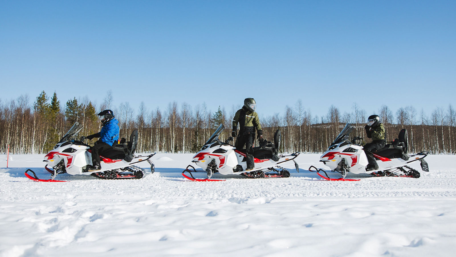 Tre Lynx Adventure Electric snöskotrar parkerade på en led
