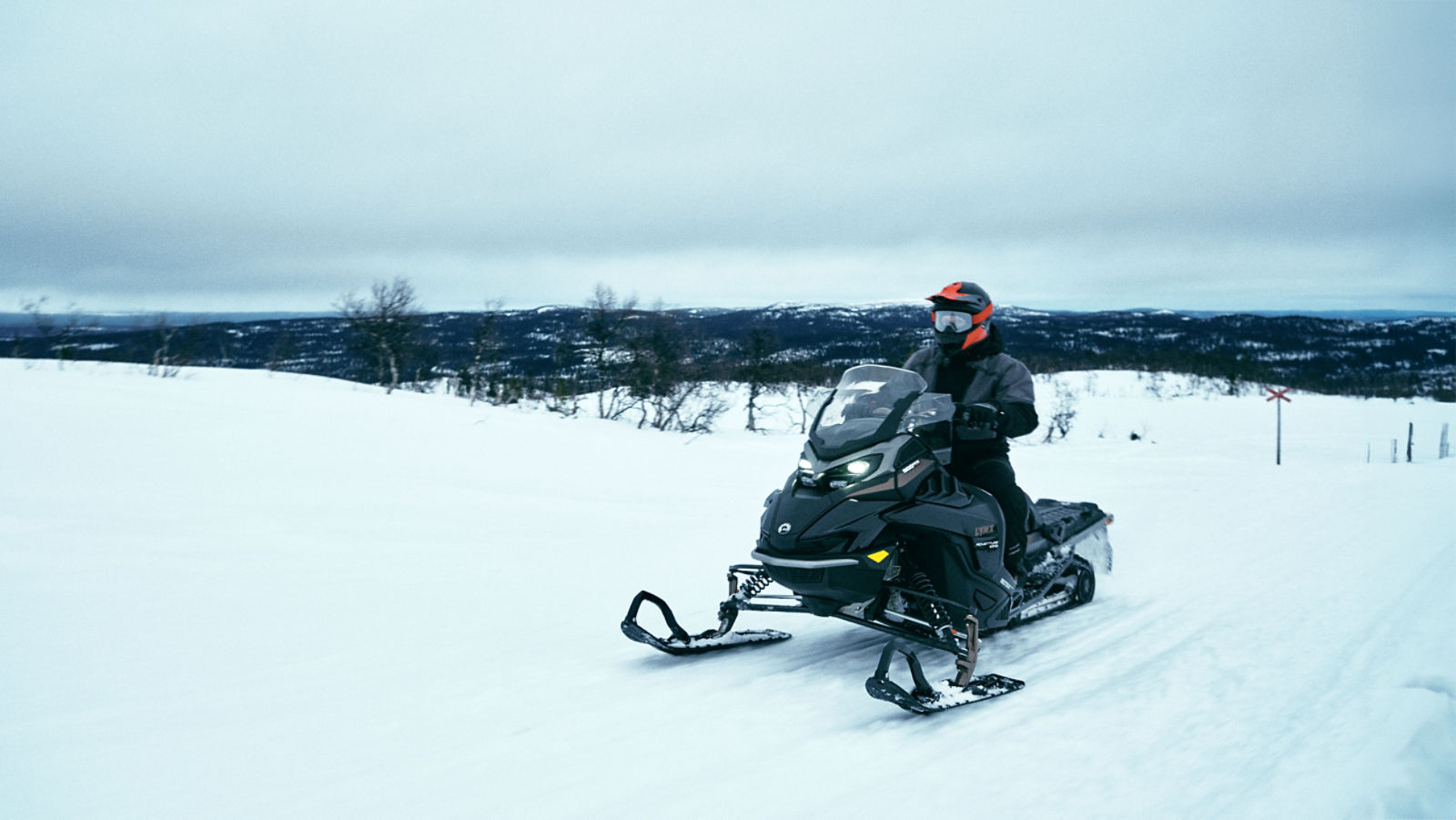 En man som åker med Lynx Adventure Limited snöskoter på ett led