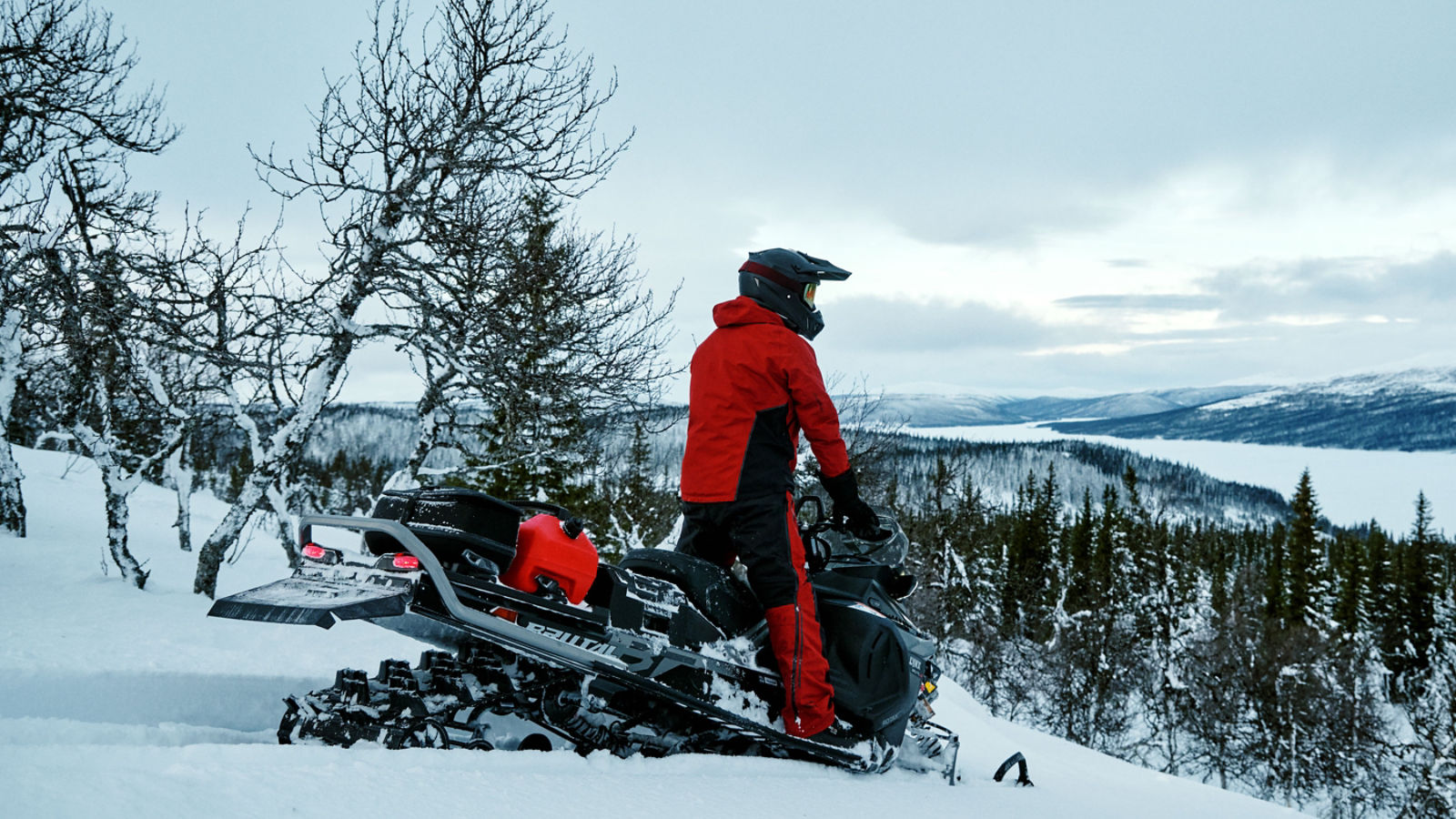 Rider standing on his accessorized Lynx Brutal snowmobile