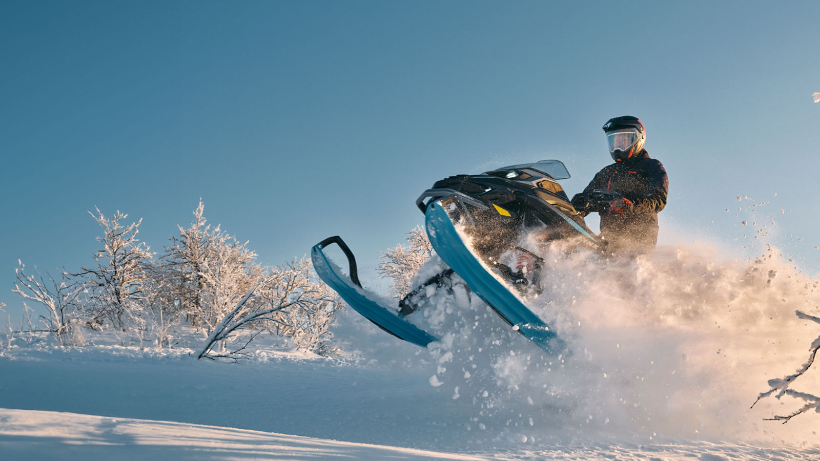 2026 Lynx Commander RE snowmobile accelerating through a wind lip