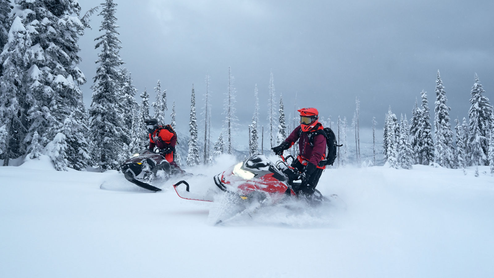 Two Lynx Shredder snowmobiles riding in deep snow