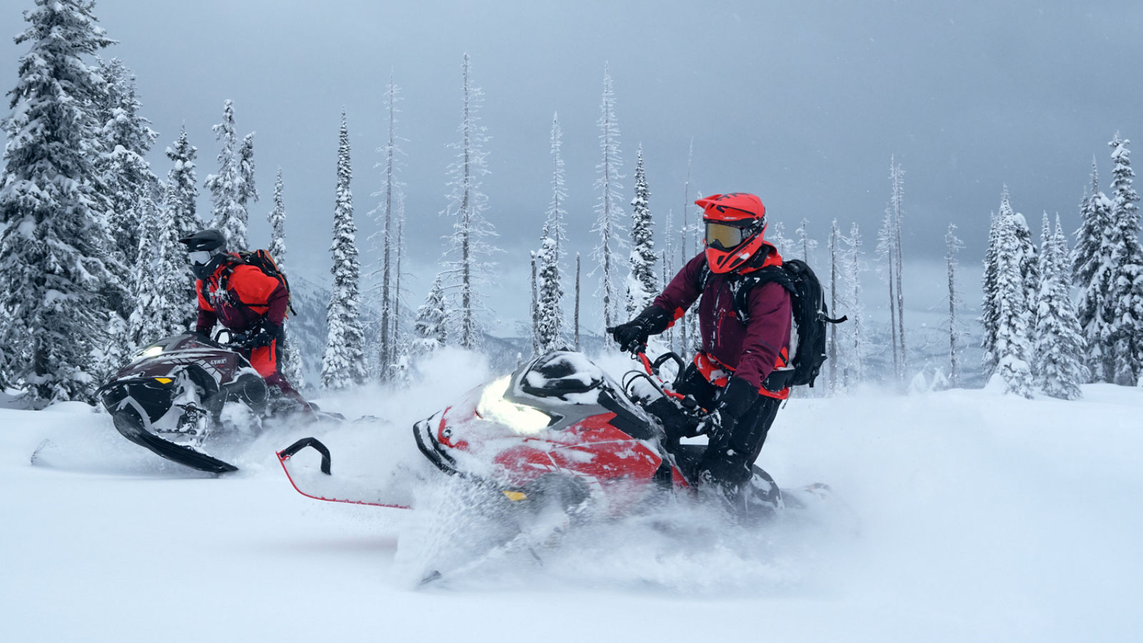 Two riders on their Lynx Shredder snowmobiles in deep snow