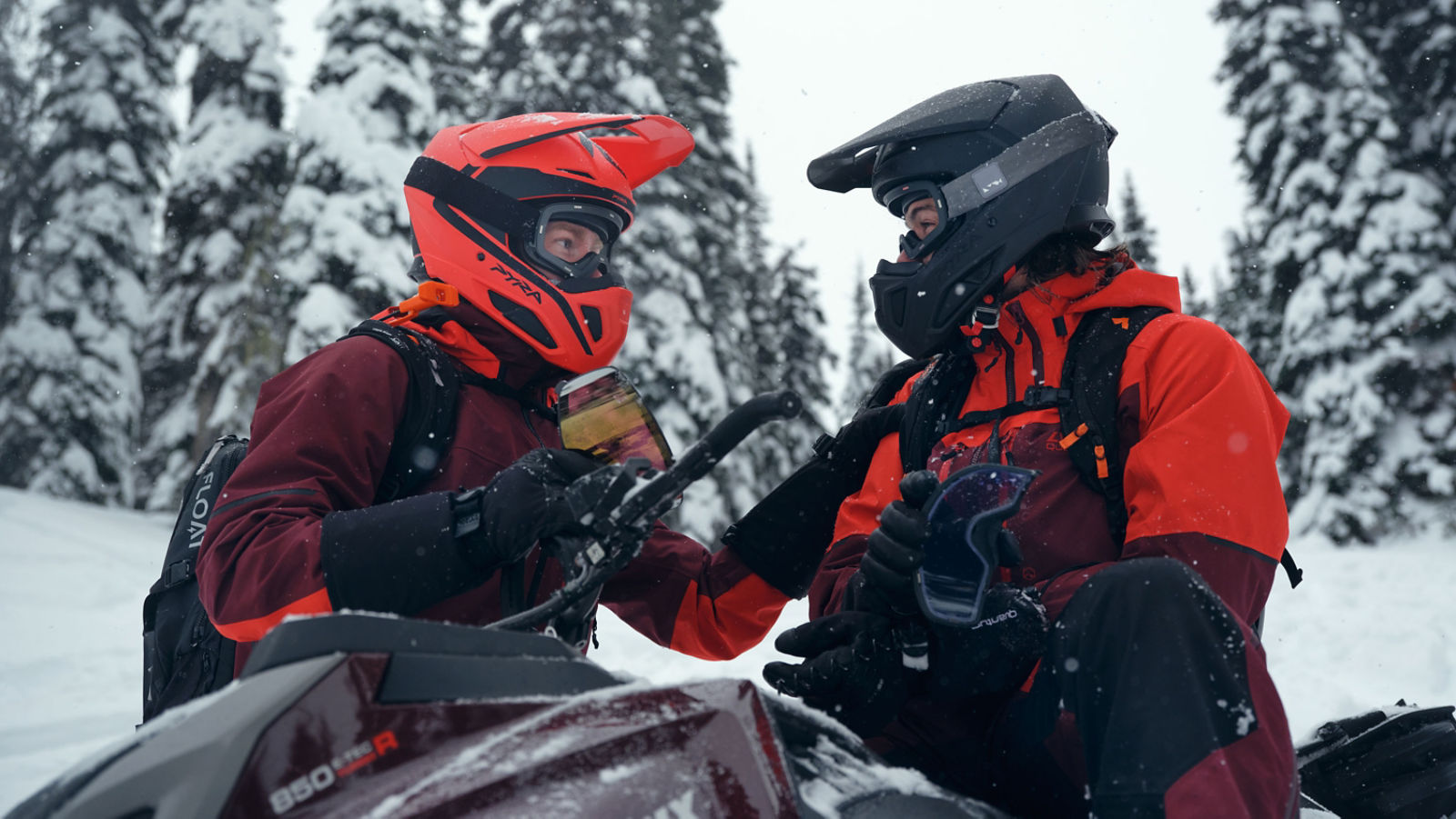 To førere iført snøscooterutstyr og Pyra-hjelm