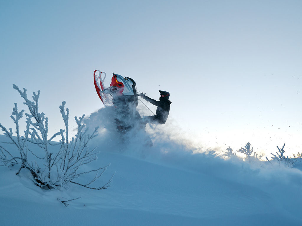 Motoneigiste qui performe une cascade avec une motoneige Lynx Shredder 202