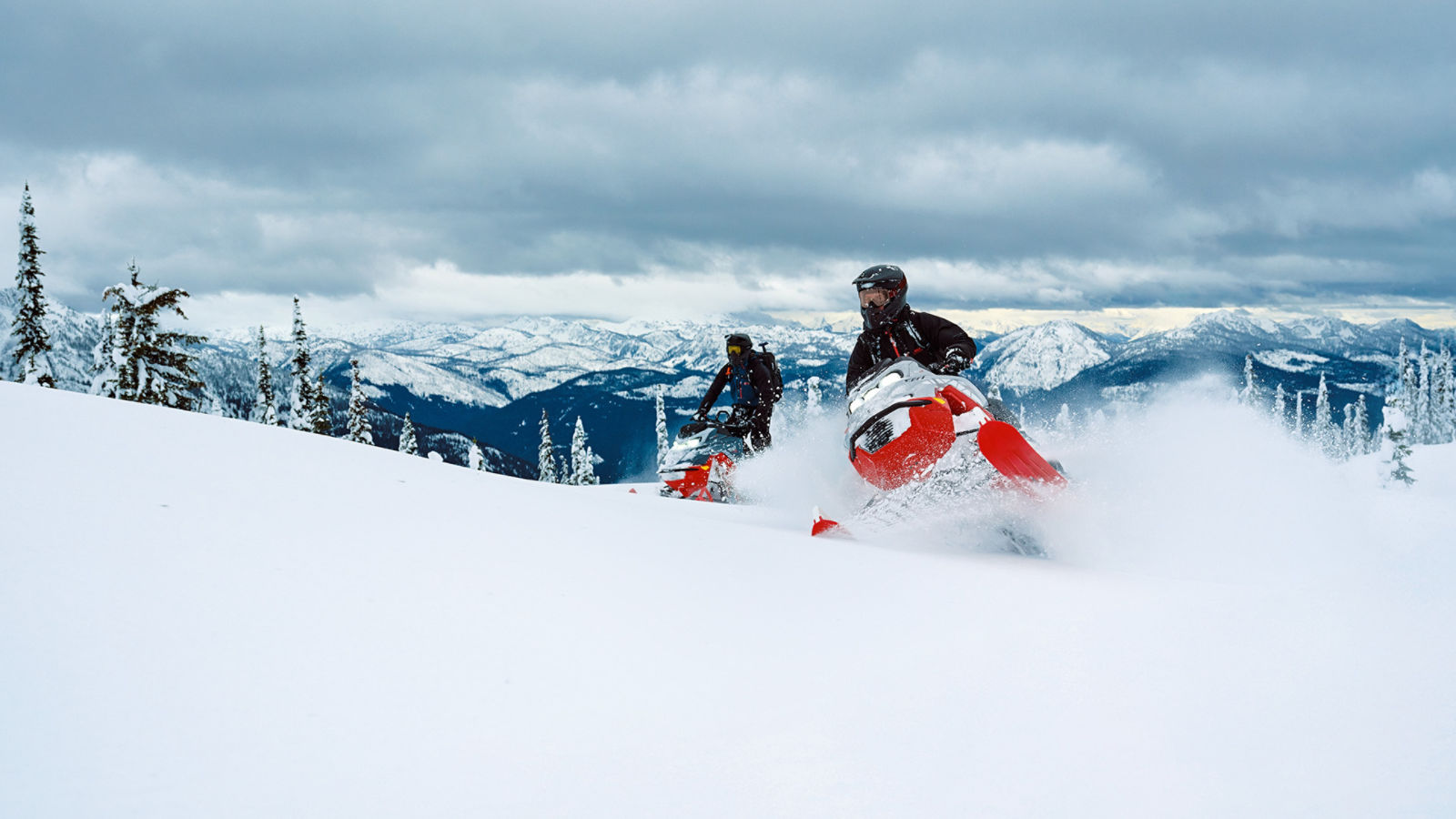 Deux motoneigistes qui monte une pente enneigée sur leur motoneiges Lynx 2027