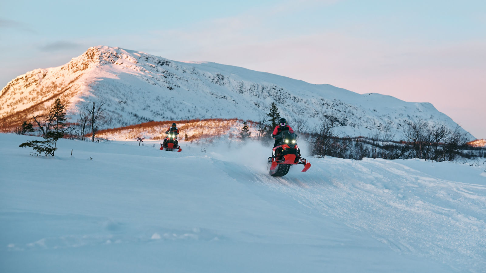 Två 2027 Lynx Rave RE snöskotrar tävlar i hög hastighet