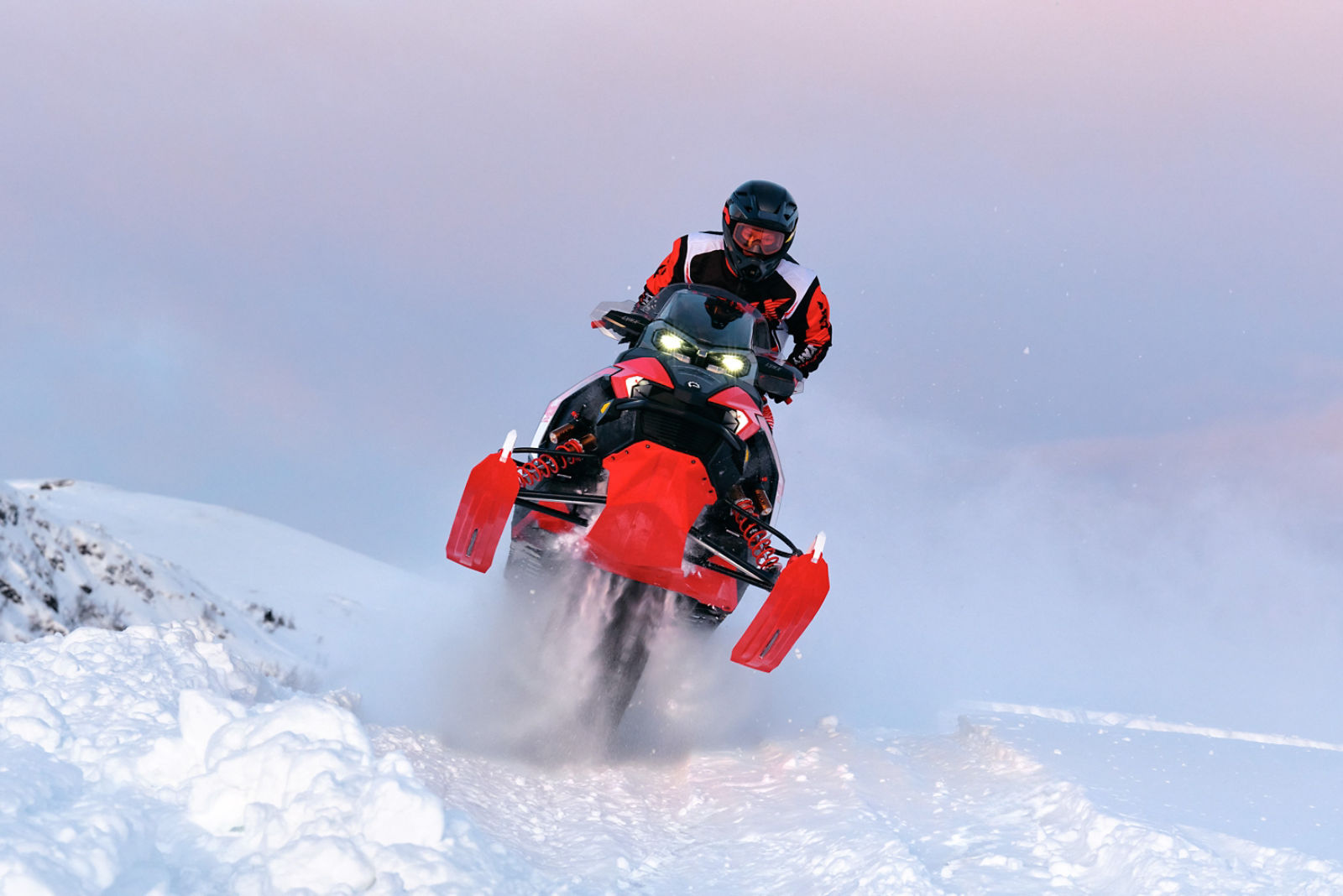 Förare utför ett hoppsprång på en 2026 Lynx Rave RE snöskoter