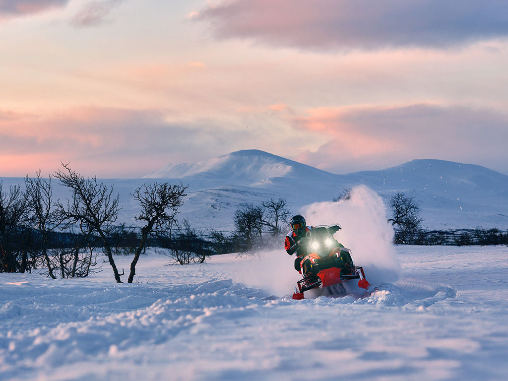 Motoneigiste en randonnée sur une motoneige Lynx Rave RE 2027 à l'aube