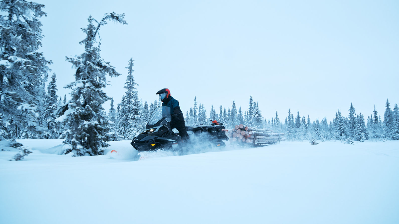 Rider pulling logs with a 2027 Lynx 69 Ranger PRO snowmobile