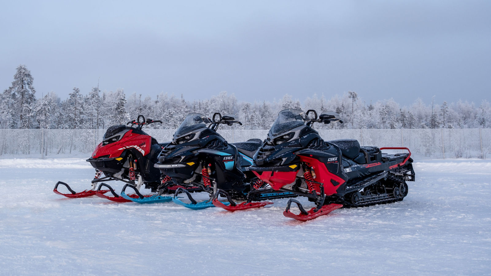 Three Lynx snowmobiles on a snowy terrain
