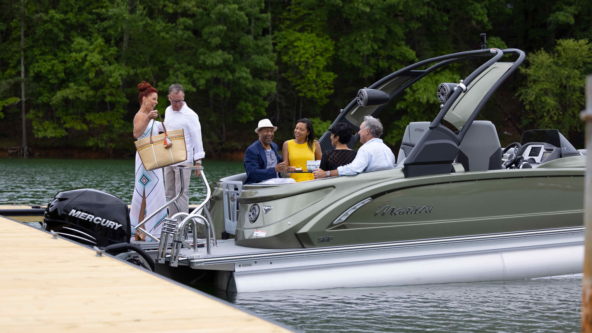 Couple boarding green Manitou pontoon