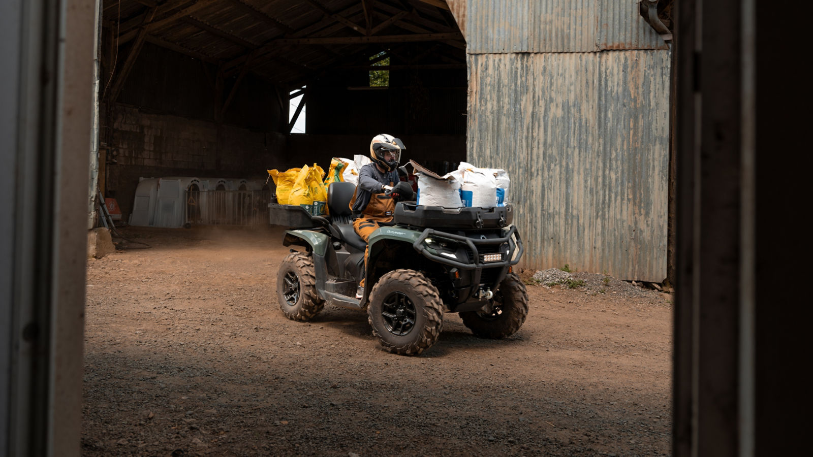 En man som använder en Can-Am Outlander PRO för att transportera material