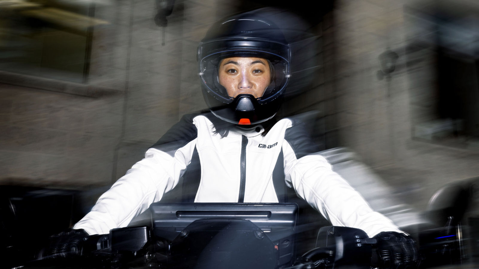 Frau mit Helm auf einem Elektromotorrad sitzend