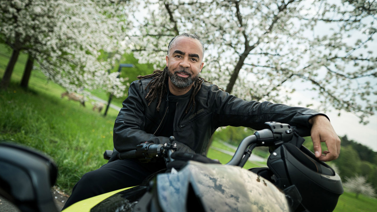 Patrick Owomoyela lacht in die Kamera auf einem Can-Am Spyder F3-S