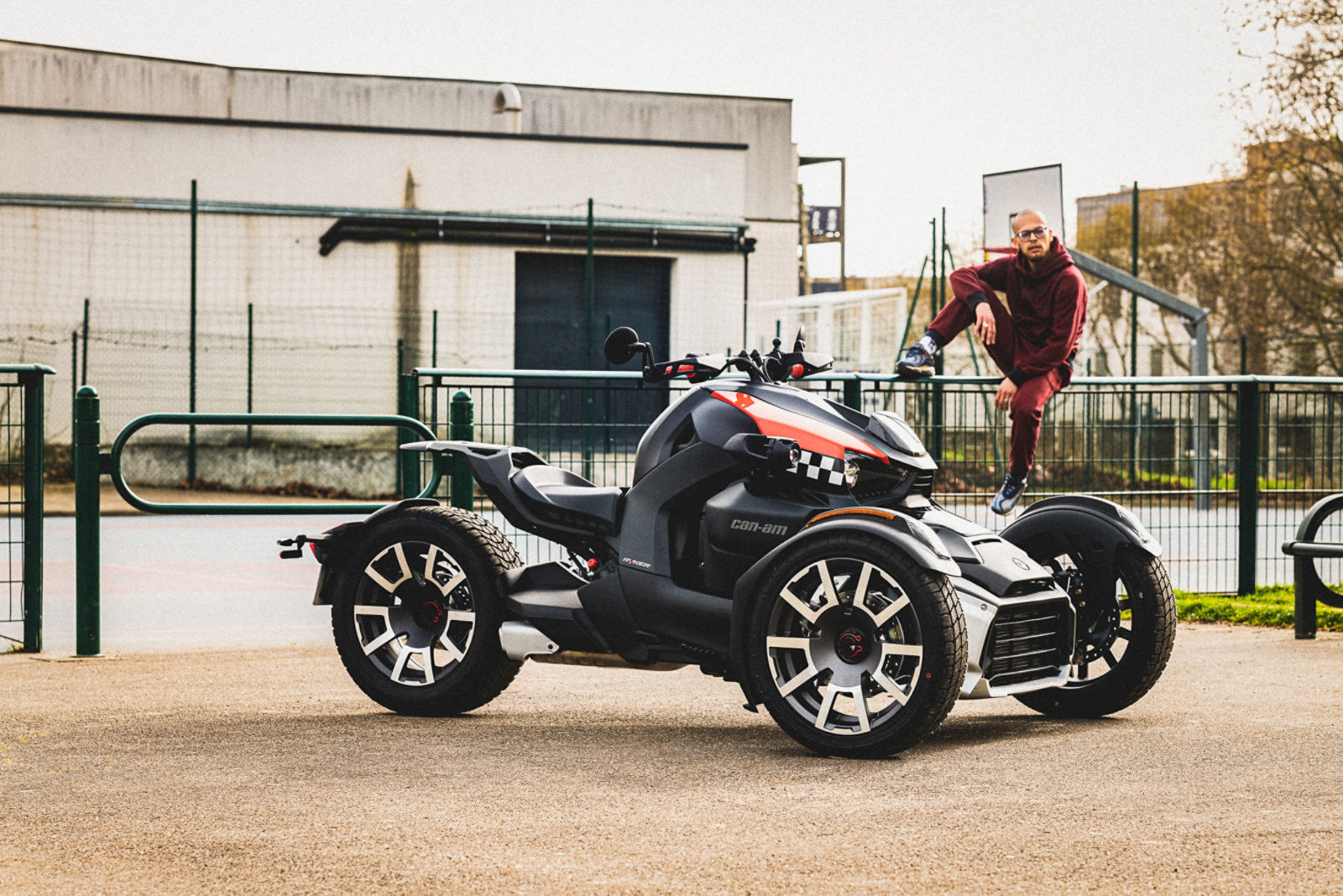 Lilou sitzt auf einem Zaun. Ein Can-Am Ryker ist im Vordergrund zu sehen