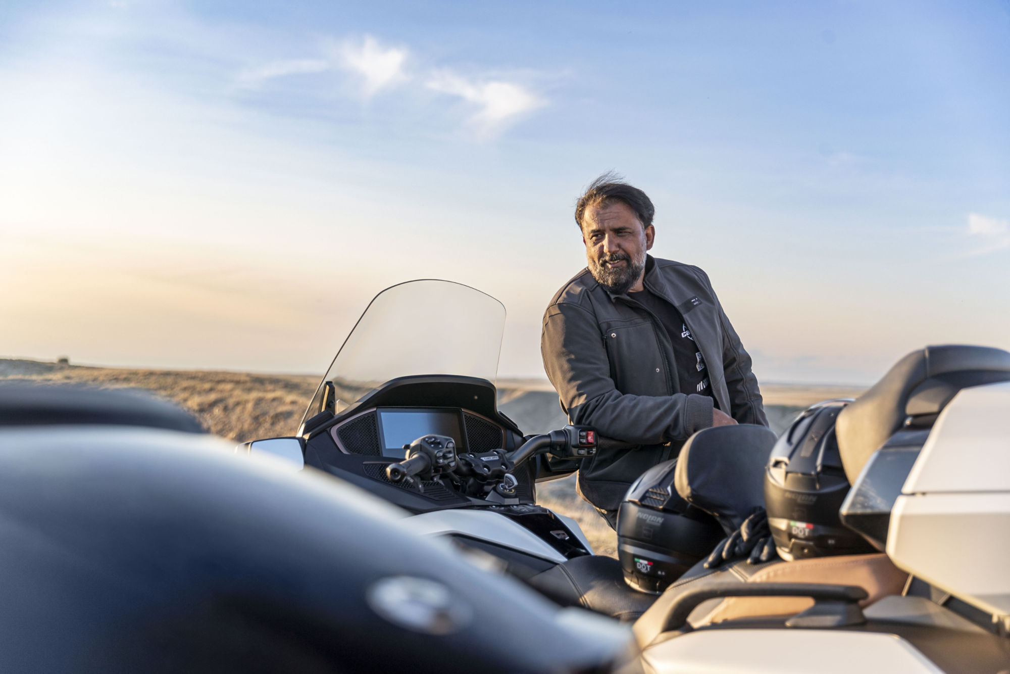 A man looking at several Can-Am Spyder RT Limited modified with touring equipment