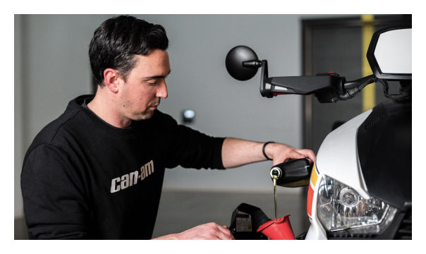 Men changing oil in a Can-Am Ryker