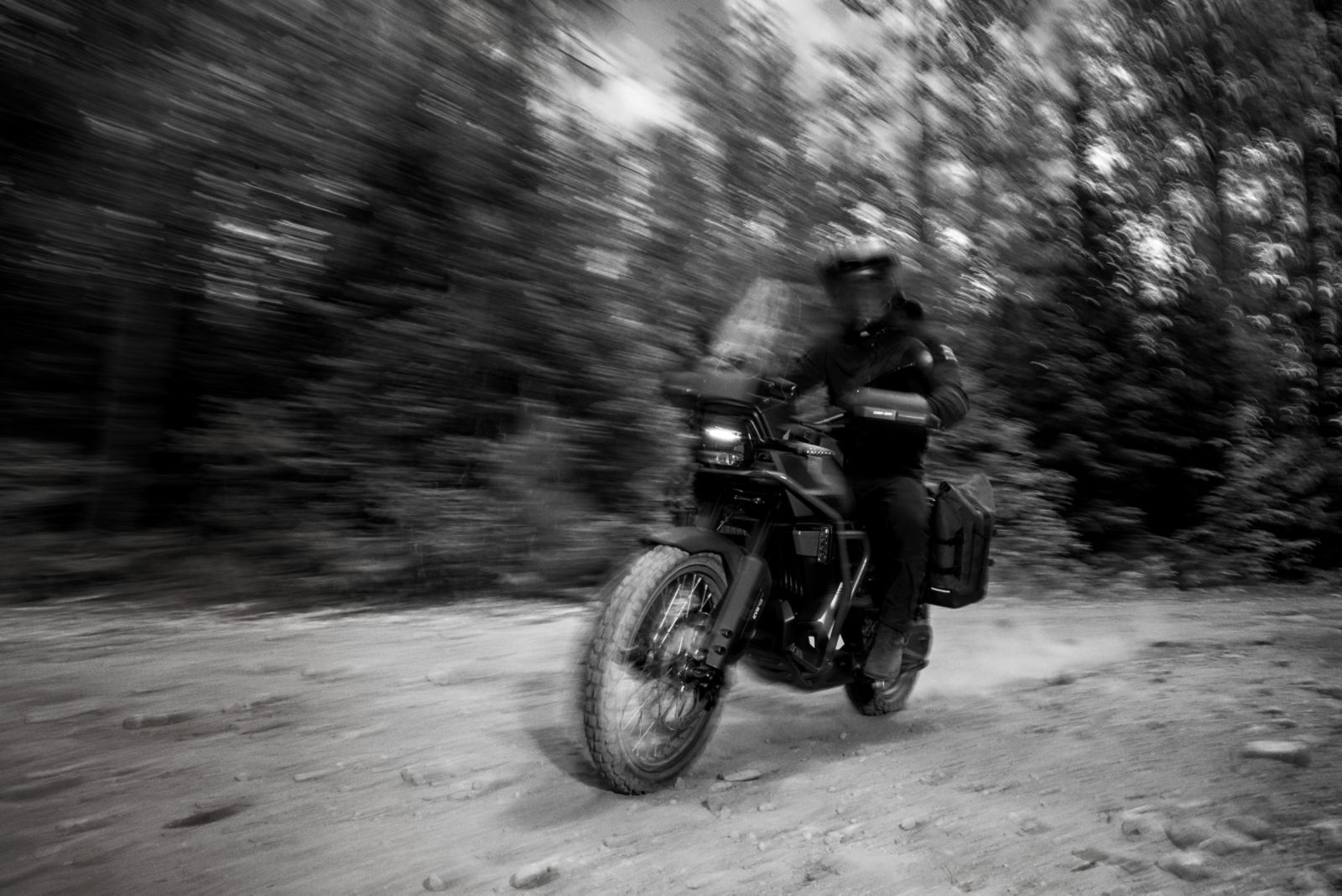 Can-AM 3-wheeled vehicle on a road passing in front of a gas station 