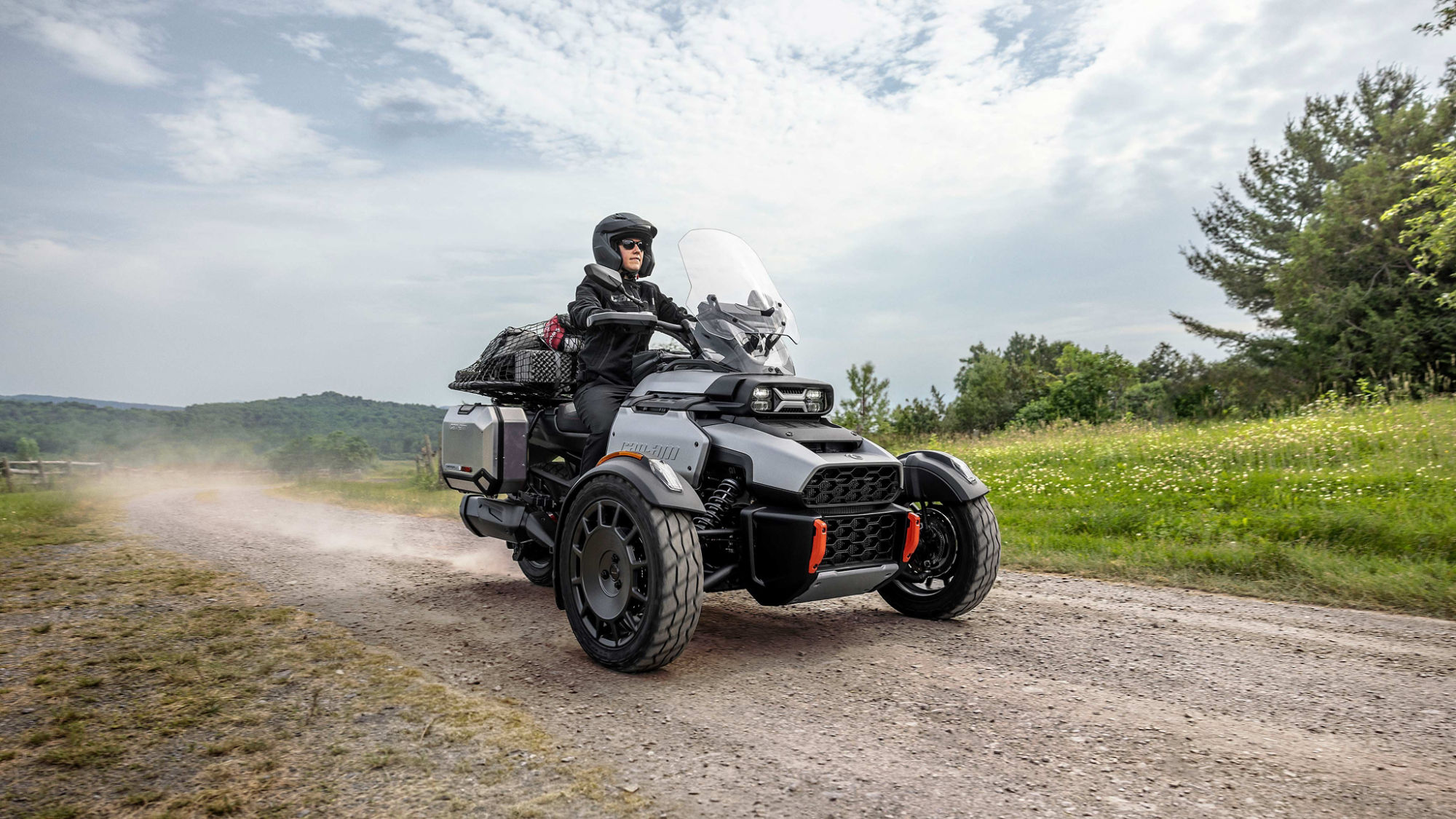 2025 fully accessorized Can-Am Canyon XT 3-wheel motorcycle riding on a dirt road