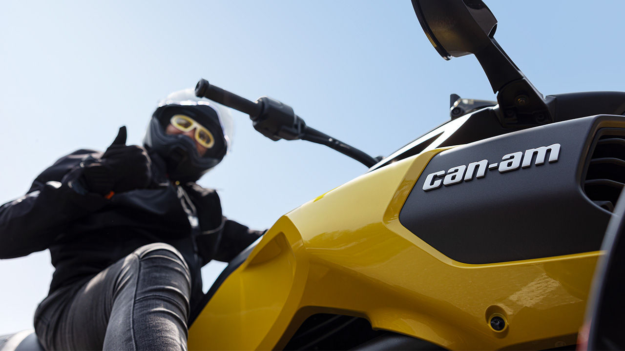 A driver checks his Can-Am 3-wheel vehicle