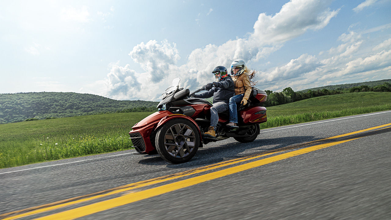 Two riders on their Can-Am 3-wheel on a calm road 