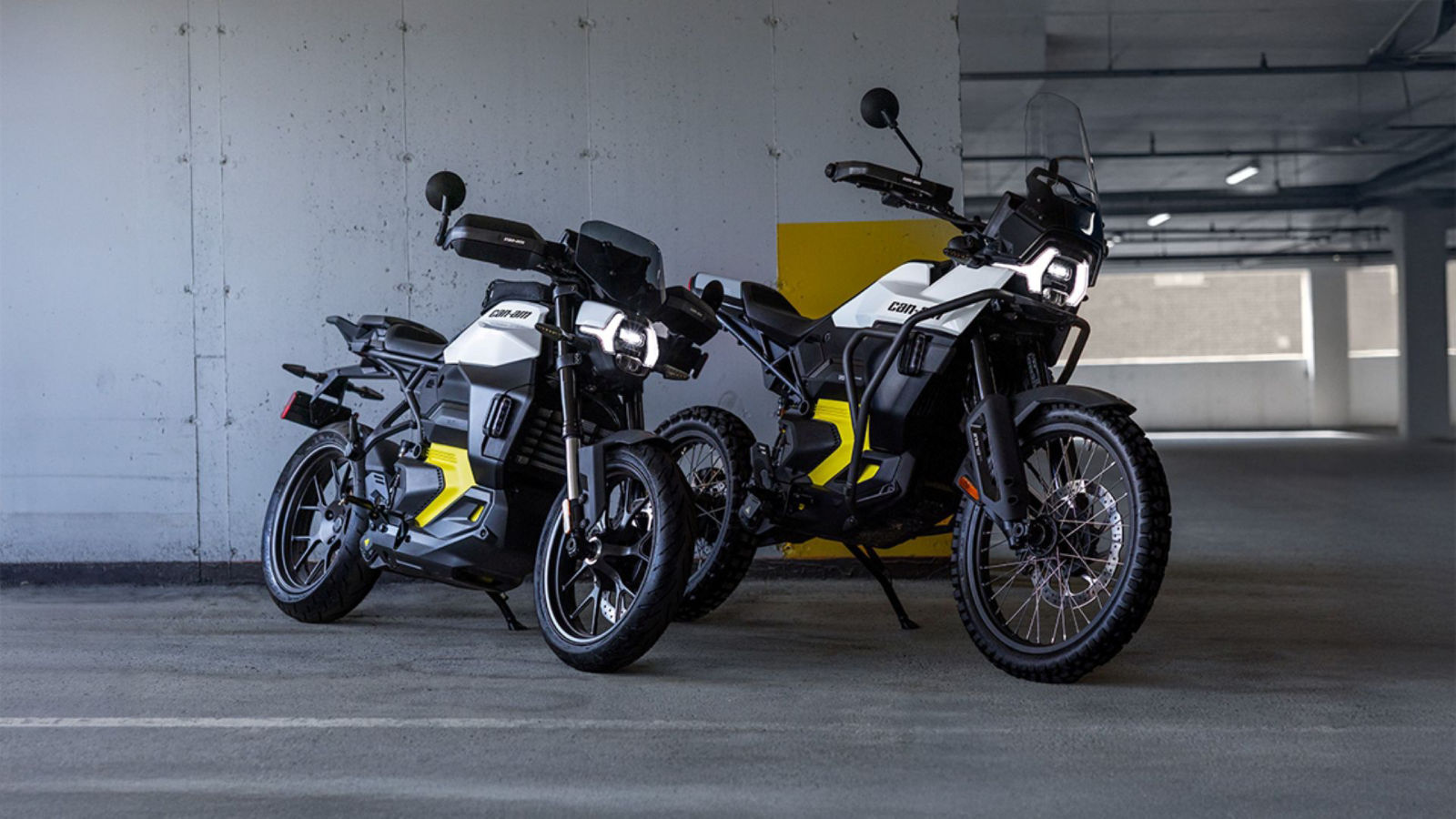 The two Can-Am electric motorcycle models side by side in a multi-story parking garage