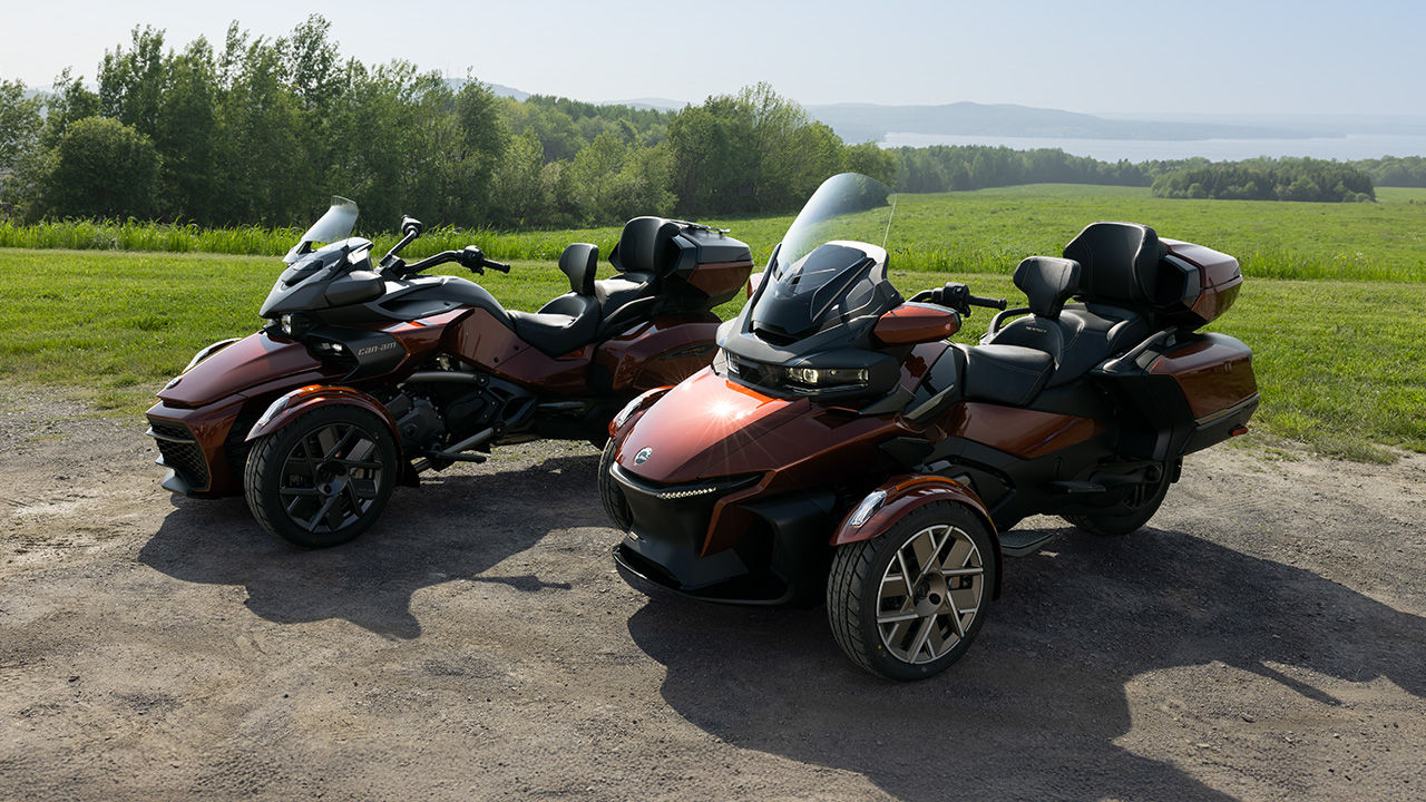 Two 2026 Can-Am 3-wheelers parked next to each other near a field