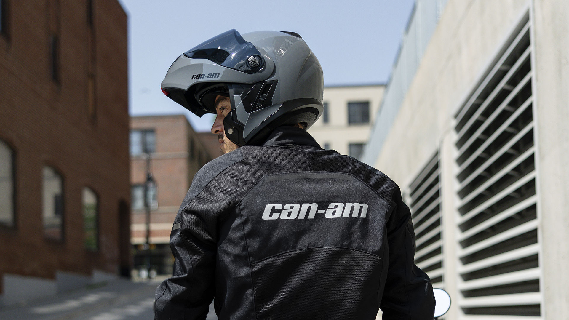 A Can-Am motorcycle rider, fully equipped with a helmet and jacket