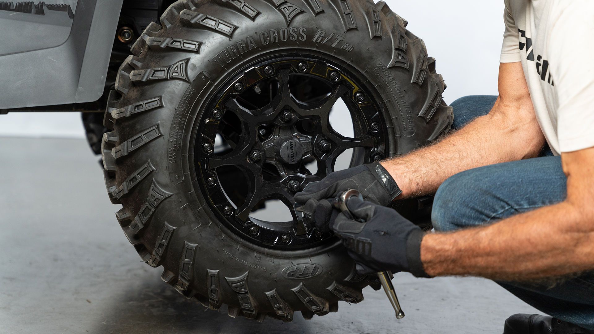 Men removing the wheel on a Can-Am Commander side-by-side