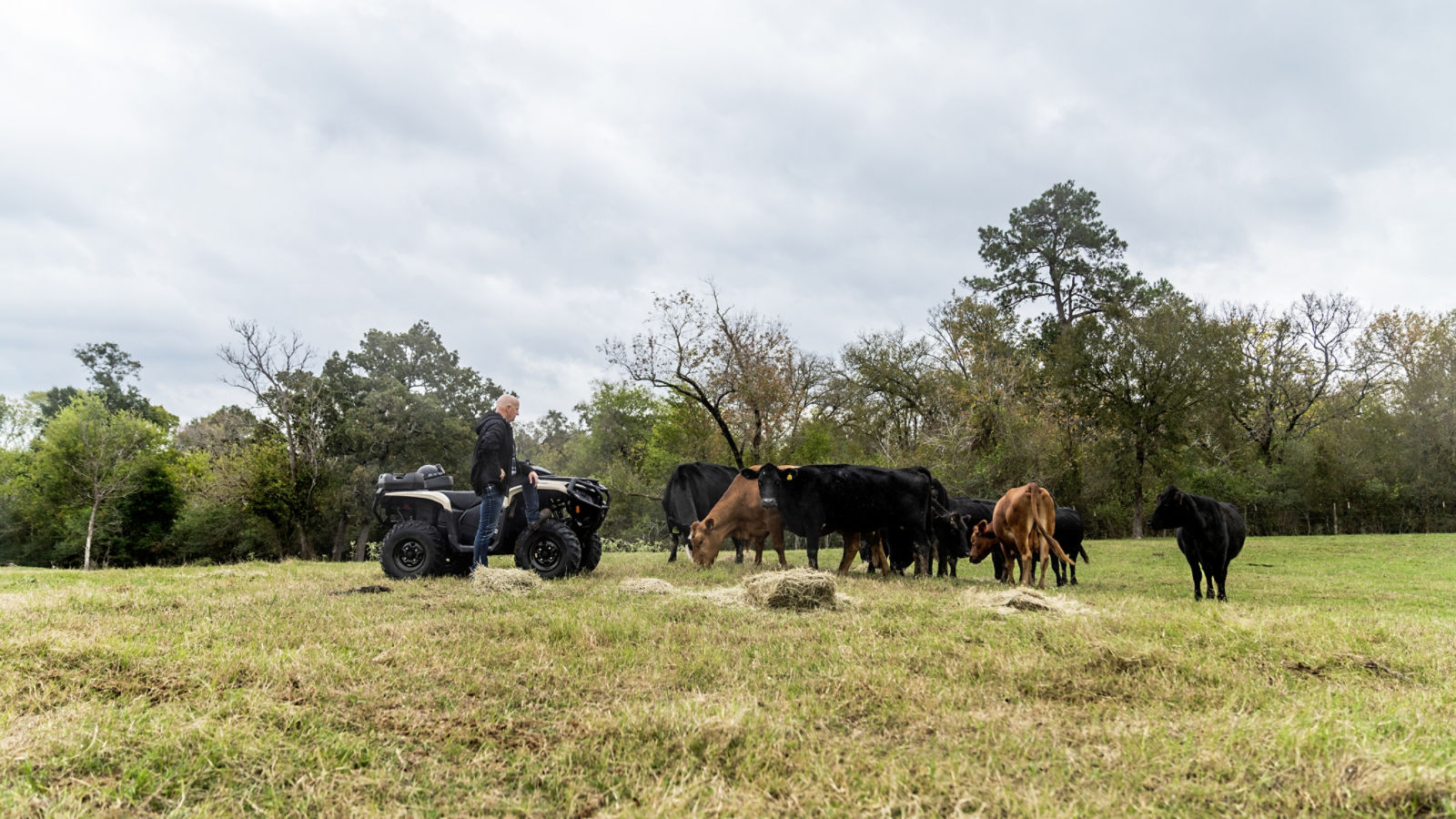 Tres Can-Am Outlander Pro aparcados delante de un granero.
