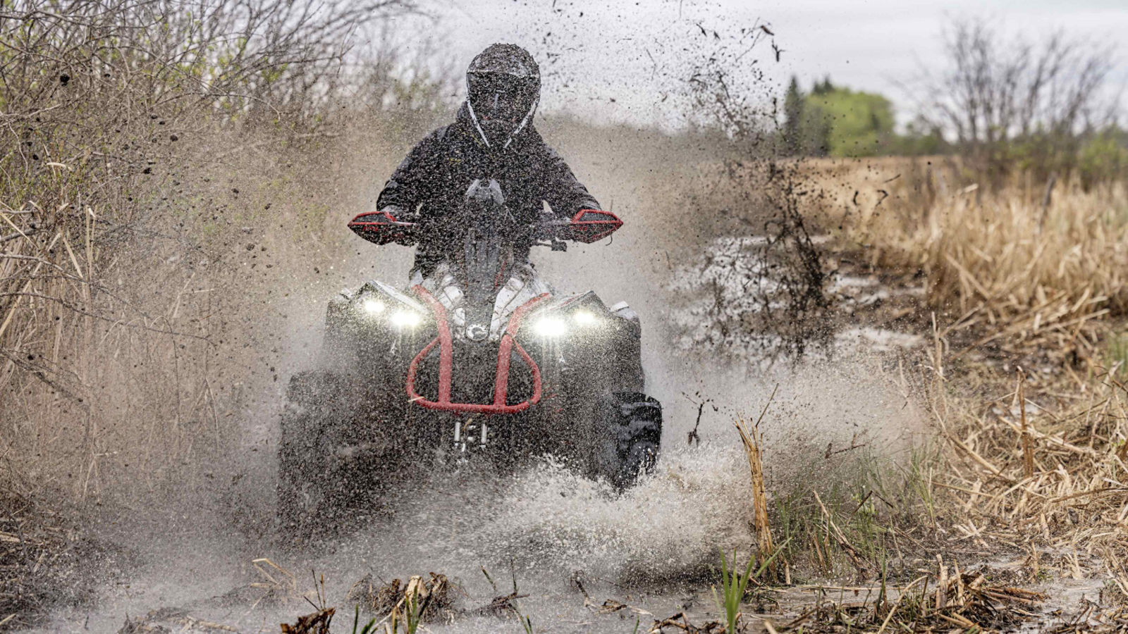 Un Can-Am Renegade 2024 equipado con el diferencial delantero Visco-4lok atravesando un charco de barro.