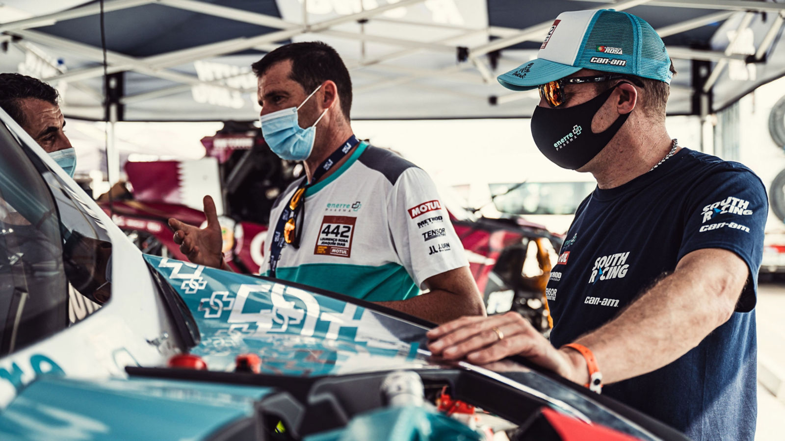 3 men with Can-Am Off-Road vehicle