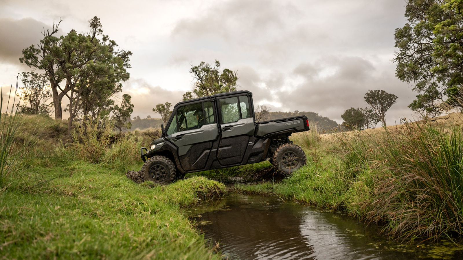 A Can-Am Defender MAX LTD HD10 crossing a stream on his farm