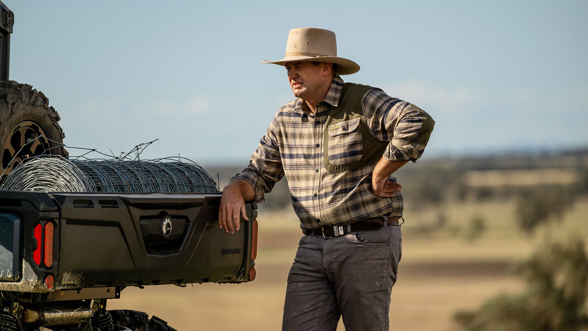 A cowboy leaning on his Can-Am Defender XT HD10