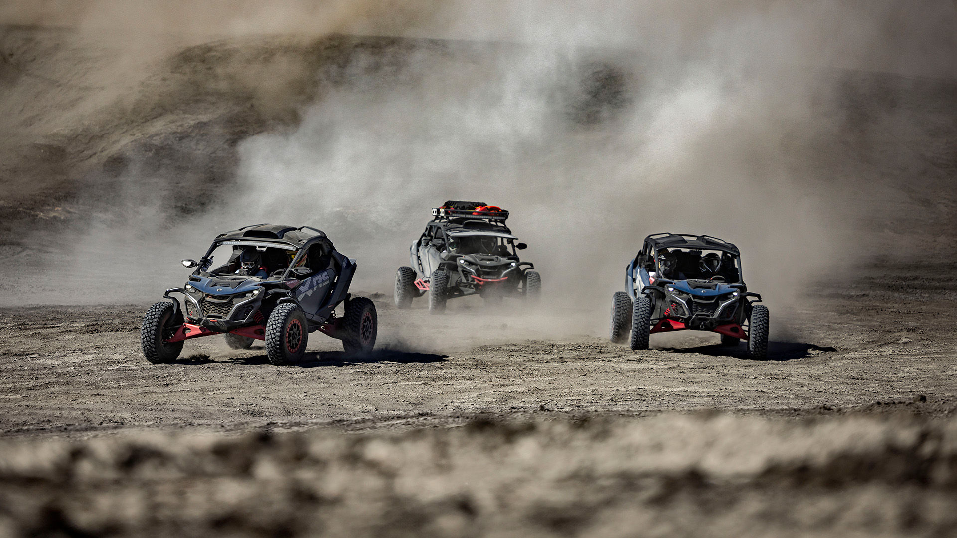 Several Can-Am Maverick side-by-side vehicles driving in the desert