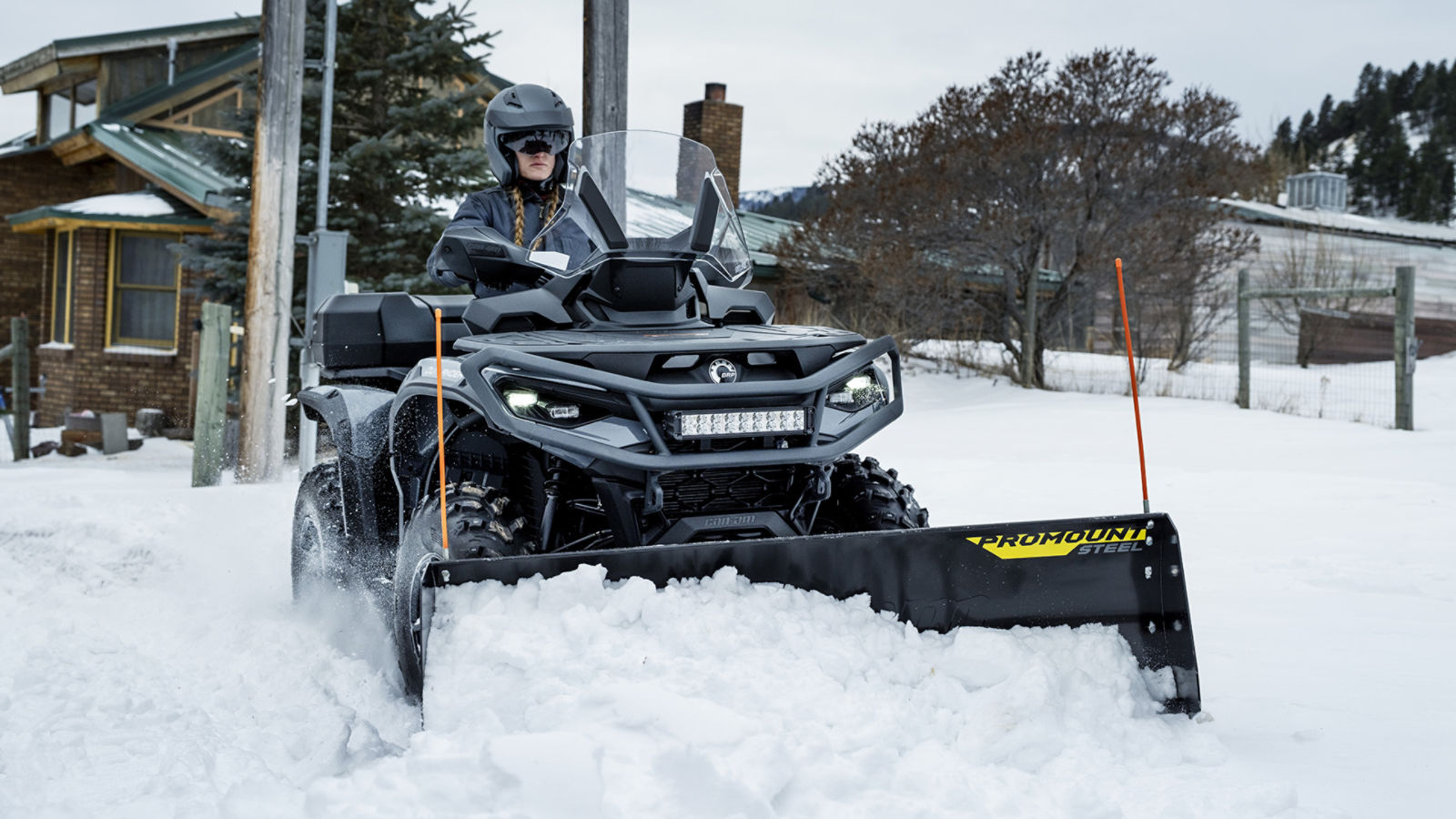 Une femme déneige avec un quad Can-Am Outlander équipé d'une lame ProMount